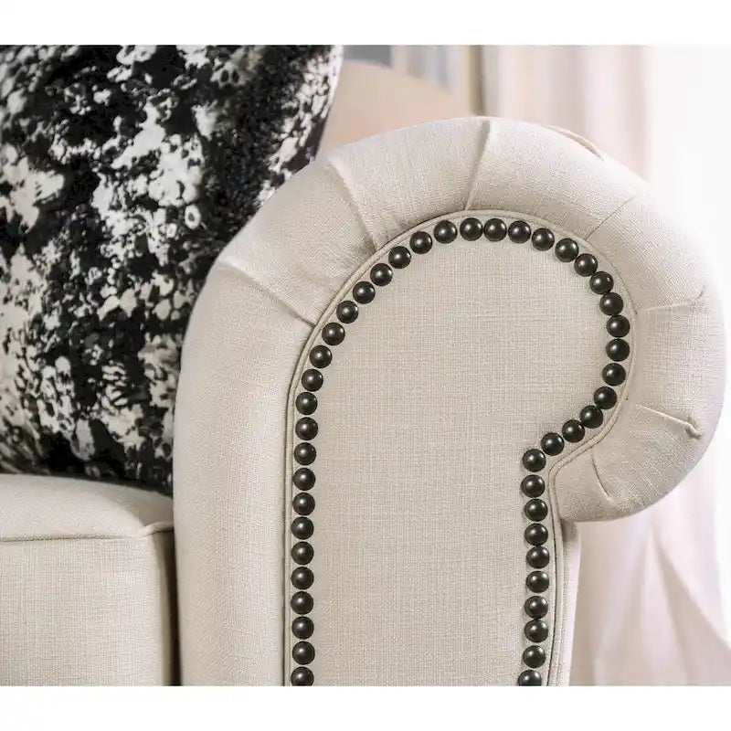 Sofá glamuroso de tela beige tapizado con botones y detalles de tachuelas