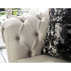 Sofá glamuroso de tela beige tapizado con botones y detalles de tachuelas
