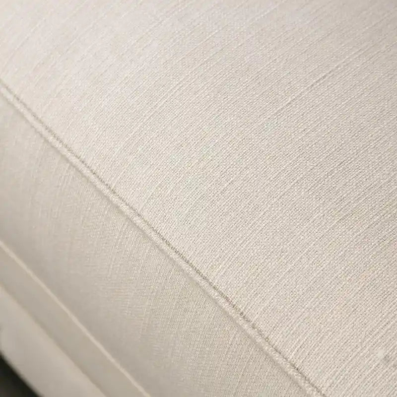 Sofá glamuroso de tela beige tapizado con botones y detalles de tachuelas